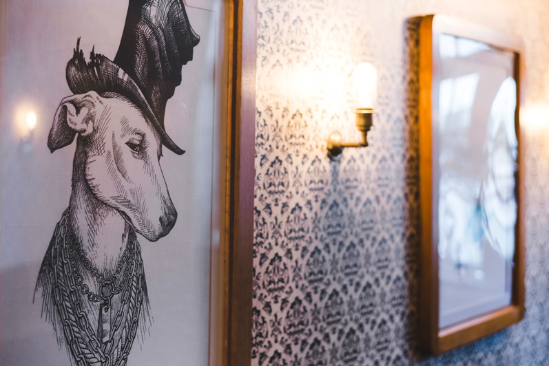 Our namesake — a framed illustration of a whippet in a top hat, hung on
patterned wallpaper