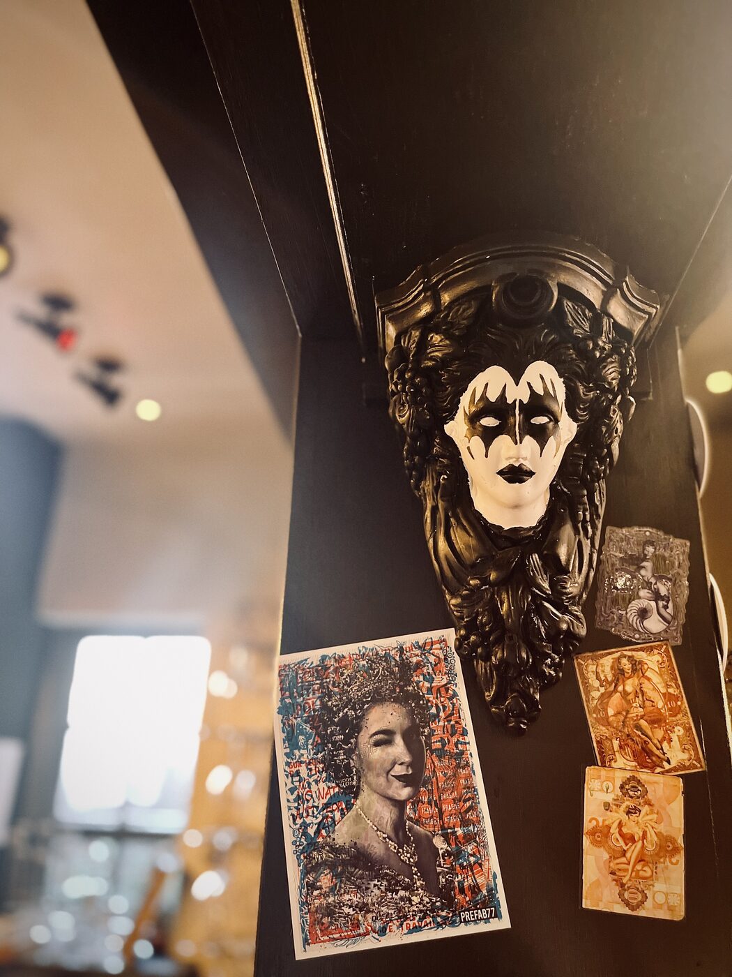 Eclectic, edgy wall art at The Whippet Inn — a carnival mask and vintage pin-up
prints against the dim, moody bar